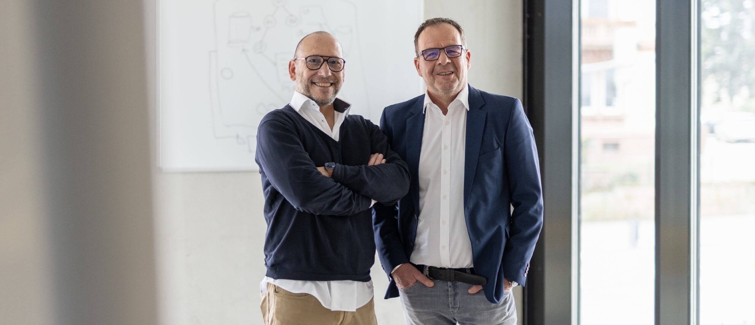 Portrait der zwei Geschäftsführer vor Whiteboard Objective Partner